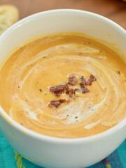 Roasted Butternut and Red Pepper soup in a bowl topped with crumbled bacon