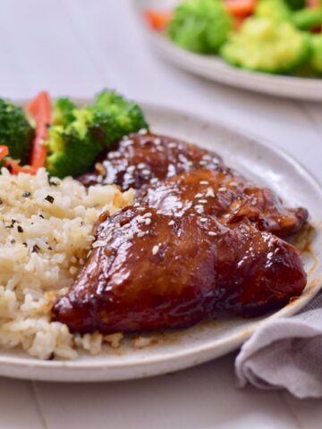 low carb sesame ginger chicken on a plate with rice and vegetables