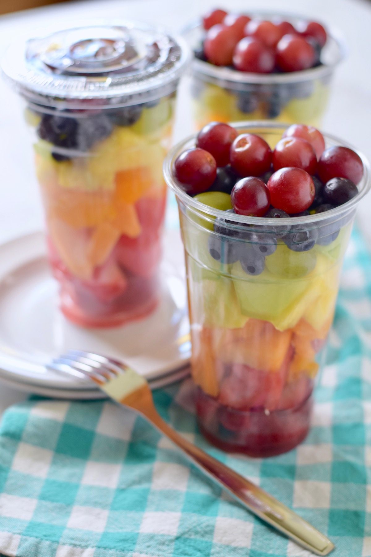 rainbow fruit salad in cup with fork