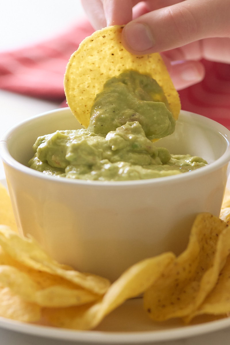 chip being dipped into guacamole