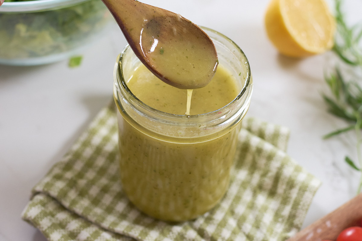salad dressing drip from spoon into jar